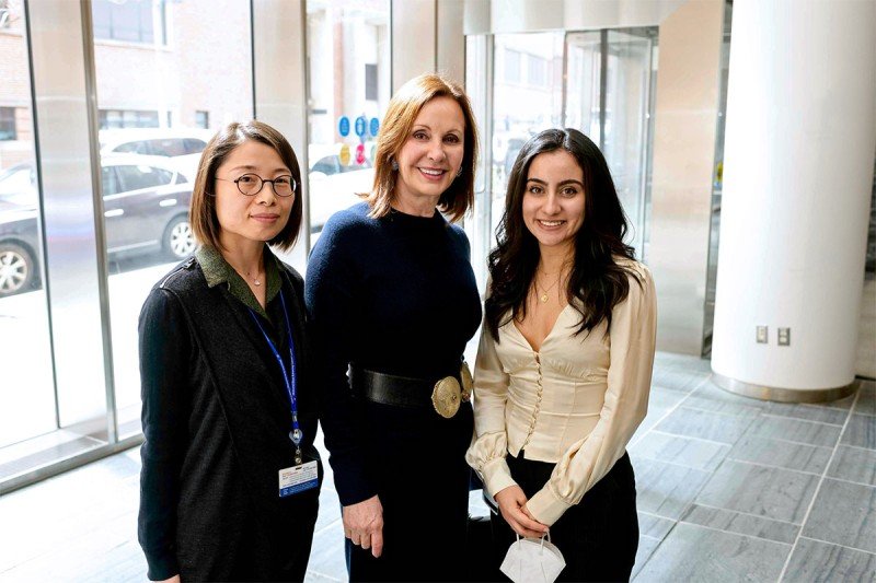 Three women standing next to each other in a lobby