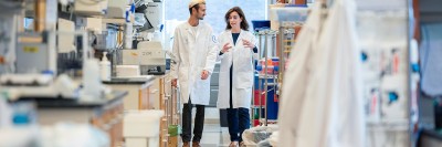 GSK Graduate Student and Adrienne Boire, MD, PhD walking together in lab.