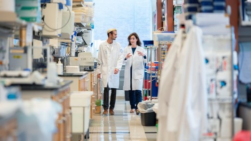 GSK Graduate Student and Adrienne Boire, MD, PhD walking together in lab.